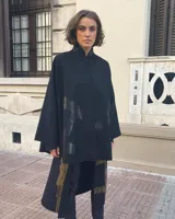 Capa negra de paño de lana con cuello mao y cierre frontal con ganchos ocultos. Estampado serigráfico negro brillante en cuerpo y cuello.