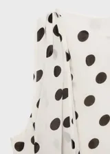 Blusa color crema con estampado de lunares marrones, cuello redondo, sin mangas y cierre de botón en la parte posterior. Incluye forro interior.