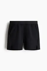 Short deportivo negro a media pierna confeccionado en tejido funcional con tecnología DryMove™, elástico en la cintura con cordón de ajuste oculto, bolsillos al bies, diseño reflectante en la parte posterior y aberturas laterales cortas en el bajo.