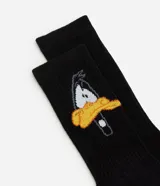 Par de medias de caña media color negro con estampa de Daffy Duck y logo de Looney Tunes.