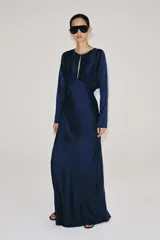 Vestido largo de satén color azul marino, de manga larga y escote redondo con pliegues en el pecho.
