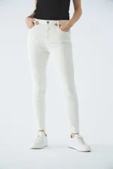 Jean de corte skinny y tiro alto, color blanco, con cierre frontal de cremallera y botón, bolsillos laterales y traseros.