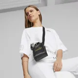 Bolso tote mini Puma Core Up, color negro con logo dorado estampado en el frente, doble asa corta y correa larga ajustable para el hombro.