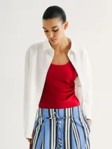 Musculosa de tela acanalada con cuello redondo y pliegues laterales que aportan textura y un ajuste entallado al cuerpo.