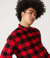 Camisa de manga larga confeccionada en franela de algodón, con estampado de cuadros en rojo y negro, cuello inglés y cierre frontal con botones.