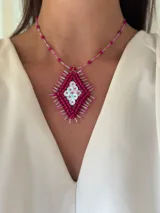 Collar corto con dije de rombo bordado con mostacillas y lentejuelas a mano, y cadena tensada. Se cierra con cadena de acero quirúrgico y ganchito para regular el largo.