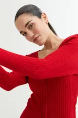 Sweater negro de tejido de punto acanalado, con escote en V y cierre frontal con cremallera circular.