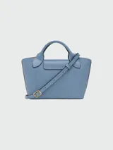 Cartera tipo shopper tamaño XS de la línea Épure de Longchamp, confeccionada en cuero de color verde menta. Presenta una estructura rígida, asas cortas superiores y un cierre de solapa con botón a presión metálico dorado.