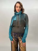 Buzo de punto confeccionado en 100% lana merino con efecto degradé en tonos azules. Presenta un diseño versátil con lazos largos que nacen de la cintura alta para anudar de diferentes formas, mangas entalladas con ojal para el pulgar y cuello redondo.