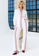 Pantalón blanco de corte recto con franjas laterales a rayas rojas, bolsillos laterales y cintura elastizada.