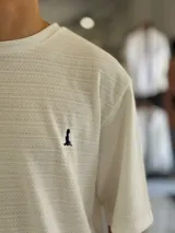 Remera oversize de tejido texturizado en color verde militar, con cuello redondo y mangas cortas. Presenta un pequeño bordado blanco en el pecho.