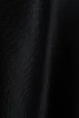 Capa de punto fino suave color negro, con escote bote y diseño amplio de caída fluida.