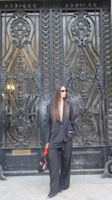 Pantalón de vestir negro con diseño de rayas diplomáticas blancas, corte recto y holgado, con bolsillos laterales.