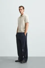 Polo de manga corta color verde oliva, con cuello solapa y abertura frontal tipo polo. Presenta una textura acanalada vertical y un calce regular.