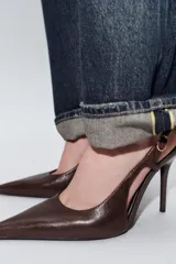 Zapato de tacón alto fino en piel color bordó, con diseño de tira trasera ajustable mediante hebilla metálica, escote redondo y acabado en punta.