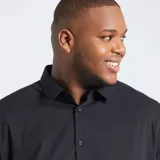 Camisa negra de corte recto, manga larga y cuello clásico. Cierre frontal con botones.