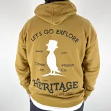 Canguro mostaza de algodón extra suave con capucha y cordones blancos. Estampa frontal con texto "Let's Go Explore", dibujo de un velero y logo "Heritage Vintage Sailing Spirit".