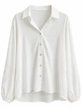 Camisa blanca de manga larga con cuello camisero, cierre frontal con botones y detalles de encaje y bordado en las mangas.