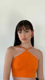 Aros colgantes con forma de flor naranja y centro con gemas rosas y rojas.