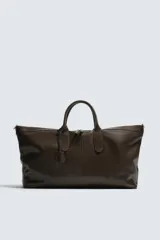 Bolso shopper de cuero vacuno con acabado abatanado, diseño minimalista con cierre de cremallera superior, doble asa de mano y detalle de llavero colgante. El interior incluye un bolsillo plano y un bolsillo con cierre.