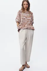 Pantalón tobillero color beige, con cintura elástica ajustable con cordones, bolsillos delanteros y falsos bolsillos con solapa en la espalda.