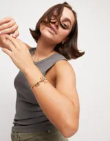 Pulsera dorada elástica con dije de libélula y dije rectangular con la inscripción "Sweet".