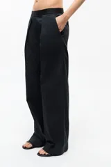 Pantalón de gabardina color beige, de corte recto, tiro medio-bajo, fit oversize y cintura elastizada con logo de la marca.