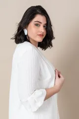 Vestido blanco con bordado de perlas y canutillos en el escote y túnica larga con tajos y ribete de satén.