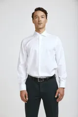 Camisa de vestir blanca de corte clásico, con cuello rígido, cierre frontal de botones y mangas largas con puños abotonados.