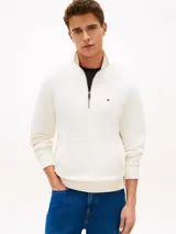 Sweater de felpa color blanco de Tommy Hilfiger, con cuello alto, cierre de un cuarto, bolsillo tipo canguro y logo bordado en el pecho.