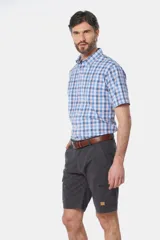 Bermuda cargo color beige con bolsillos laterales y traseros. Se ajusta a la cintura con cinturón de cuero marrón.