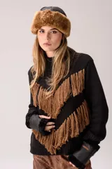 Sweater de punto color crema con cuello medio alto y silueta relajada. Presenta un diseño frontal con líneas en V decoradas con flecos largos de color marrón aplicados a mano.