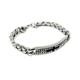 Pulsera de acero plateado con eslabones gruesos y una placa central con incrustaciones de circonias blancas y negras.