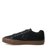 Championes Converse de estilo urbano, confeccionados en lona negra con detalles en cuero sintético. Presentan el logo de la marca en el lateral, puntera reforzada y suela de goma color caramelo (gum sole).