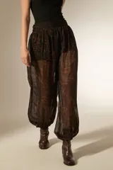 Pantalon de viscosa con diseño holgado, estampado animal print en tonos marrones y negros, cintura elástica y puños ajustados en los tobillos.