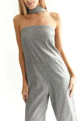 Mono strapless de lino color gris, con corte recto, elástico en la espalda y un corbatín a juego que se anuda al cuello.