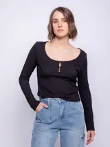 Top de manga larga ceñido al cuerpo, color negro, con escote bote pronunciado y detalle de botones forrados en el centro del pecho.