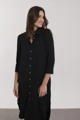 Vestido camisero midi con estampado floral en tonos naranja, rosa y fucsia. Tiene cuello camisero, mangas 3/4 y aberturas laterales.