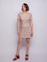 Vestido corto con estampado animal print en tonos beige y marrón, de escote cuadrado y mangas cortas.