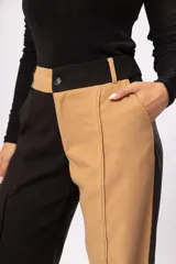 Pantalón fluido de tiro alto con bolsillos delanteros y traseros. Cierre frontal con cremallera y botón. Diseño color block negro y beige.