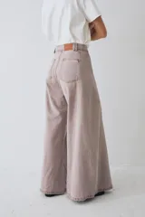 Pantalón de jean azul de tiro alto y corte wide leg súper amplio, con diseño de perneras ancha y terminación desmechada en el ruedo.