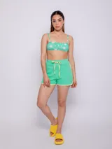 Top de bikini recto con estampado de flores y ondas en tonos verde y blanco. Tiene breteles finos regulables, se ata en la espalda y cuenta con forro y copas desmontables.