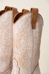 Botas texanas color marrón claro de cuero vacuno con diseño bordado en color blanco.