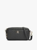 Cartera tipo cámara de poliuretano color negro, con diseño texturizado en bajo relieve con monograma TH, herrajes dorados, cierre de cremallera y correa cruzada extraíble.
