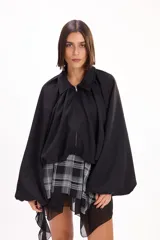 Campera negra de estilo urbano con cuello clásico, cierre frontal y mangas abullonadas amplias.
