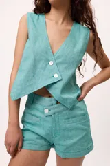 Chaleco blanco de lino y algodón, con escote en V y cierre frontal de botones.