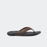Ojotas Reef con base de goma negra moldeada y tiras de cuero marrón con costuras decorativas.