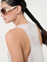 Vestido largo de corte recto con escote redondo y tirantes anchos, completamente cubierto de lentejuelas brillantes. Presenta tajos laterales en el ruedo.