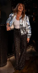 Chaqueta plateada de simil cuero, con cuello clásico, cierre frontal con botones a presión, bolsillos de parche con solapa en el pecho y mangas largas.