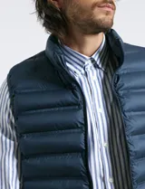 Chaleco acolchado de diseño capitoneado con cierre frontal al tono, cuello alto y ribetes en sisas y ruedo.